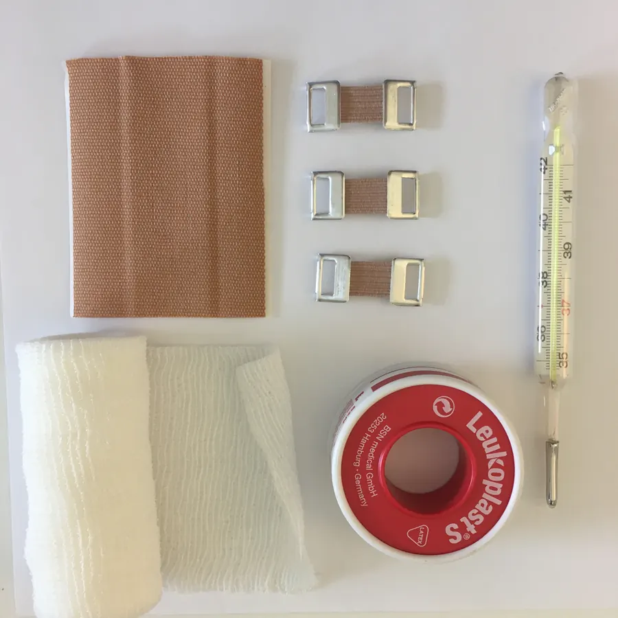 Verbandsmaterial, Pflaster, Leukoplast und Fieberthermometer übersichtlich aufgelegt
